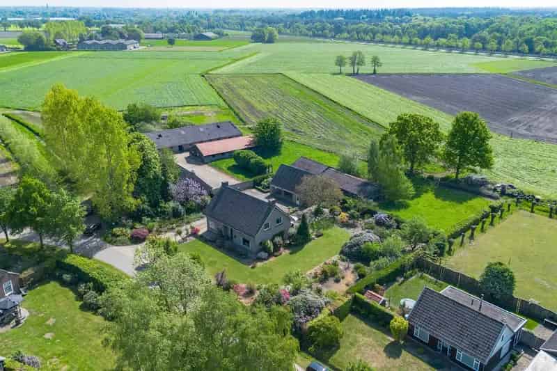 Vrijstaande woning met bijgebouwen en ruim perceel te koop