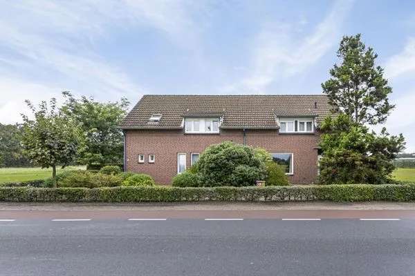 Twee onder een kapwoning met garage en loods te Horst